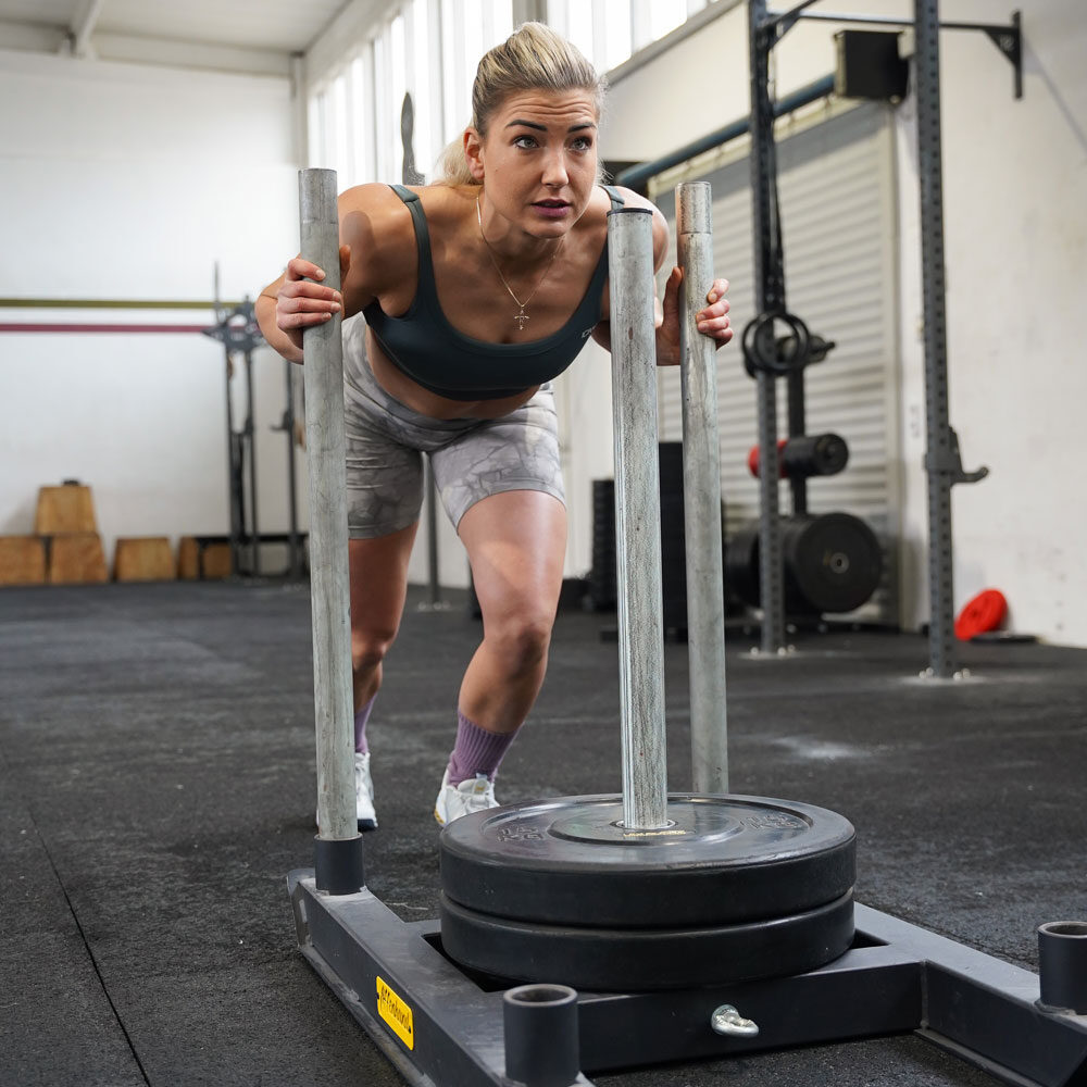 Affenhand Gewichtsschlitten – Lidia im Hyrox Push Training Athletin Lidia schiebt den Affenhand Gewichtsschlitten im Hyrox Training